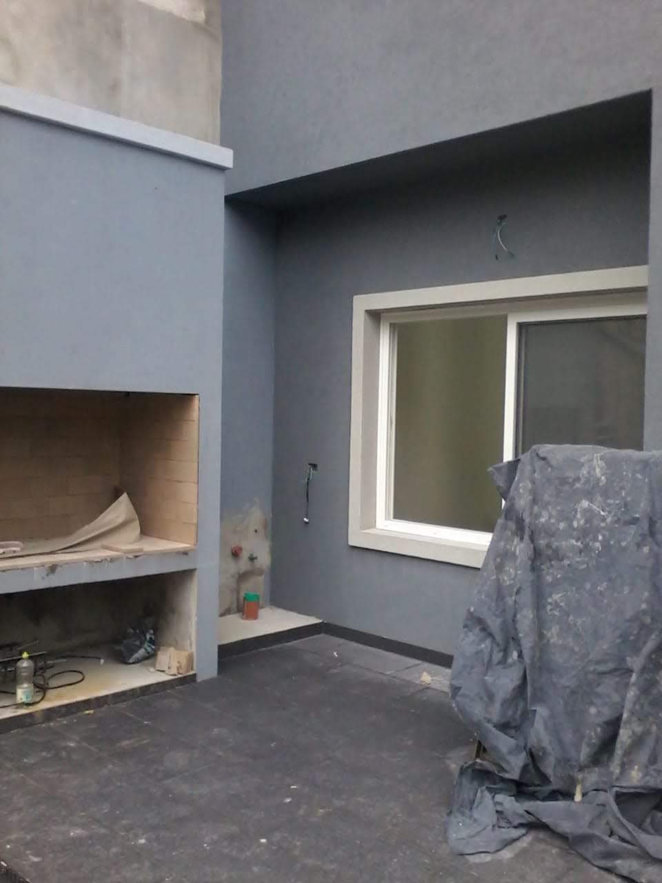 Patio con parrilla y revestimiento exterior gris